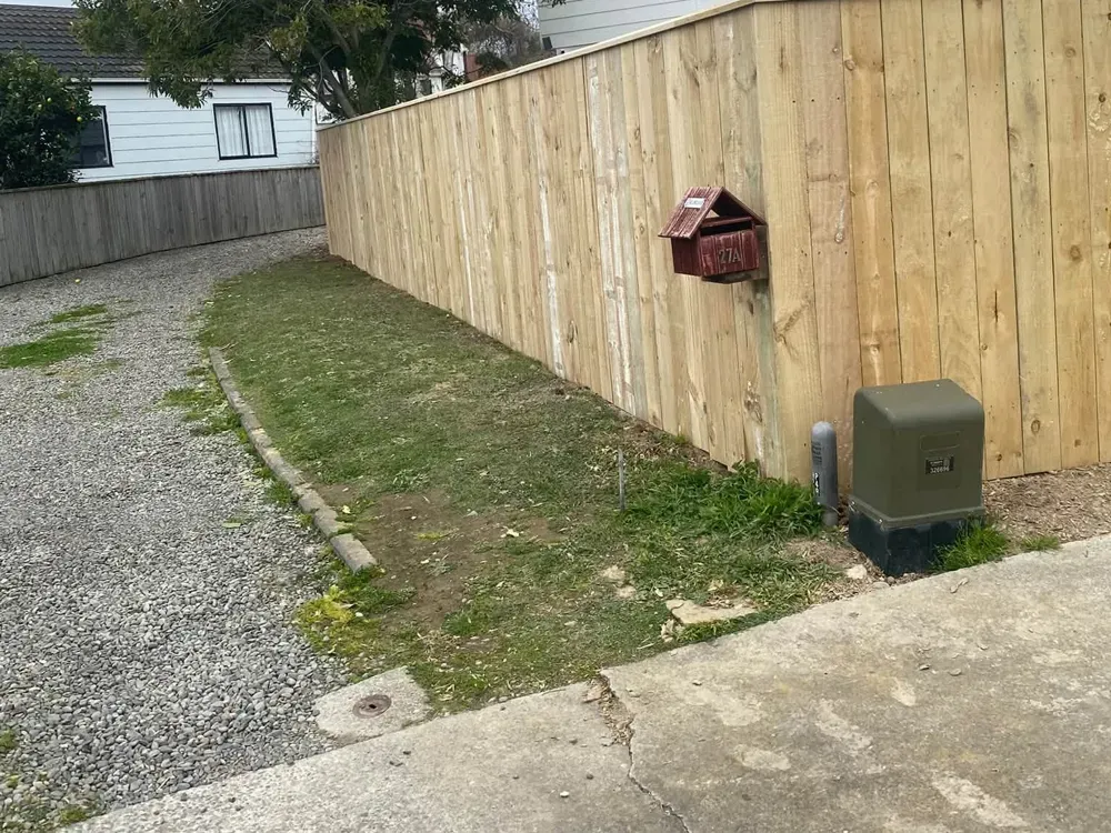 Capped timber paling fence beside a gravel driveway, Palmerston North