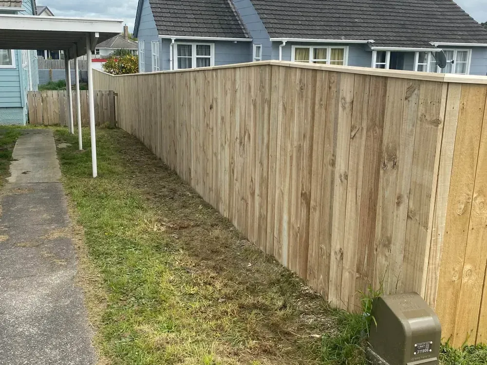 New capped timber fence along a side yard