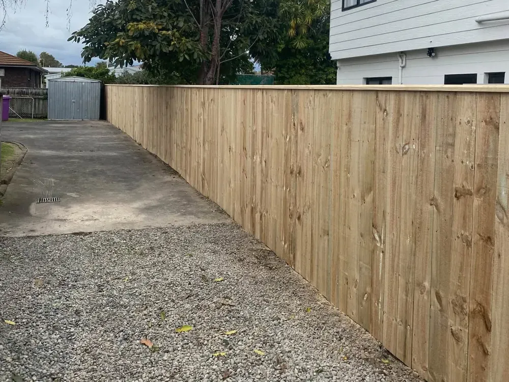 Long timber fence beside a driveway built by Rowdy Builders