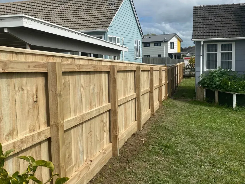 Timber fence with rails along a backyard boundary