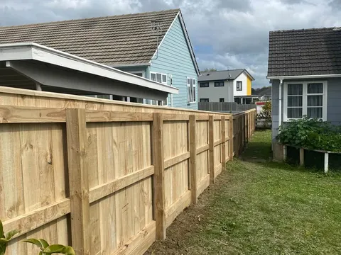 Capped timber fence with rails across a back yard, Palmerston North
