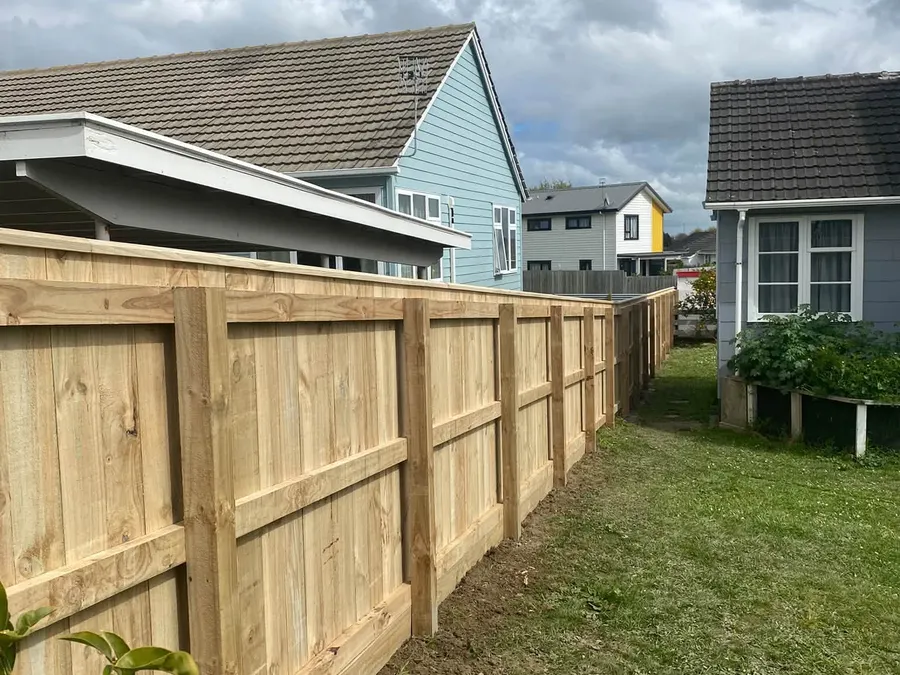 Capped timber fence with rails across a back yard, Palmerston North