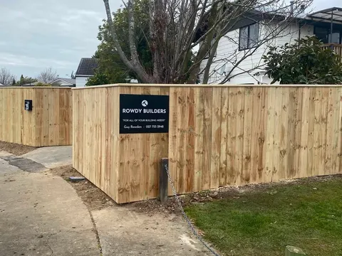 New timber fence with a Rowdy Builders sign beside a footpath, Palmerston North