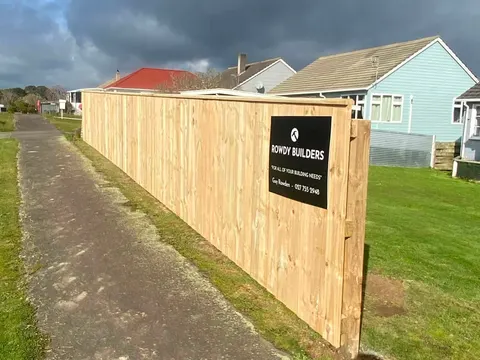 New timber fence with a Rowdy Builders sign beside a path, Palmerston North