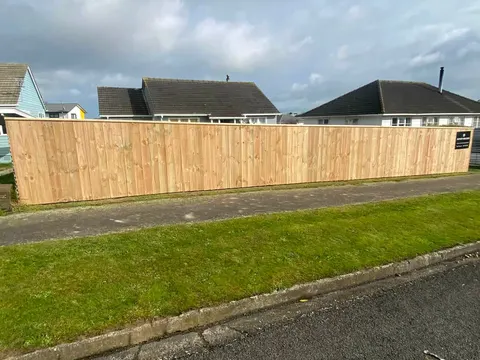 Timber paling fence across a lawn beside a road, Palmerston North