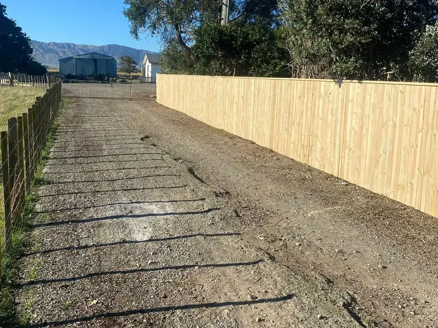 New timber fence along an open driveway with the hills behind, Manawatū