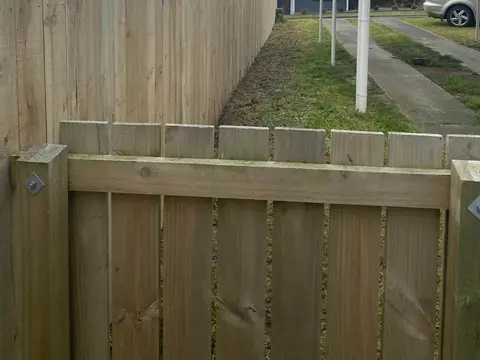 Timber gate set into a timber paling fence